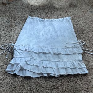 Super cute white mini skirt with ties on the sides!